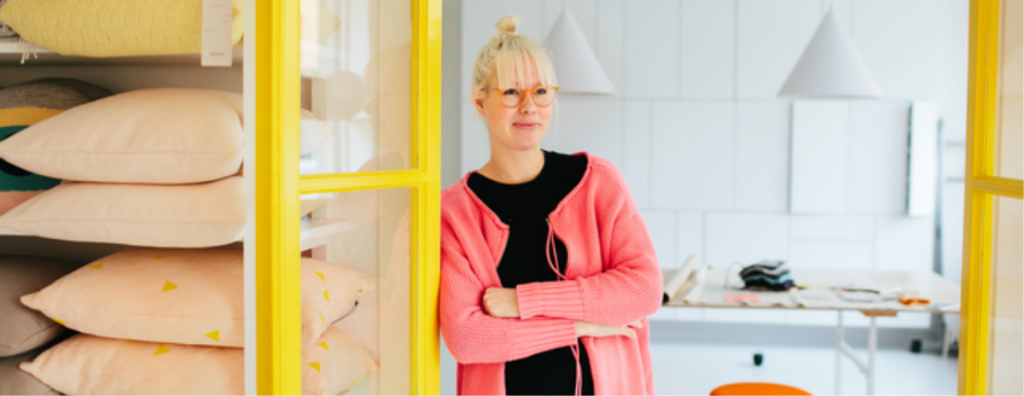 Dame lener seg til dørkarm i tekstilbutikk
