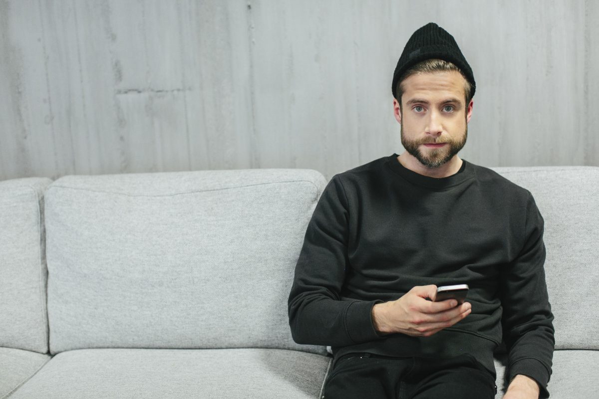 Mann som sitter i sofa
