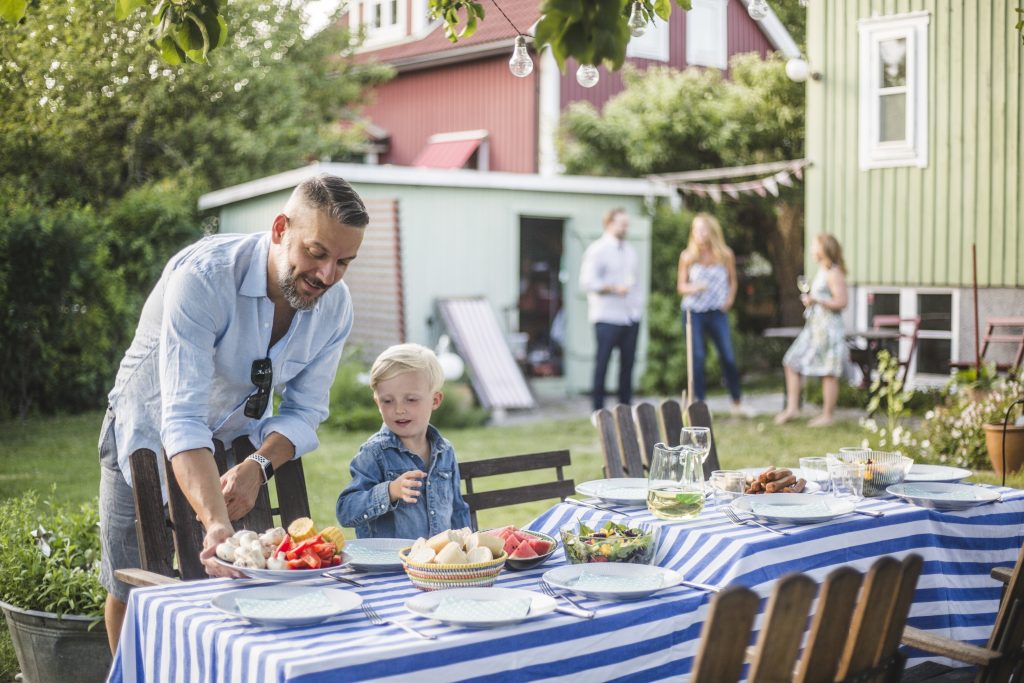 Mann-dekker-bord-i-hagen-familie