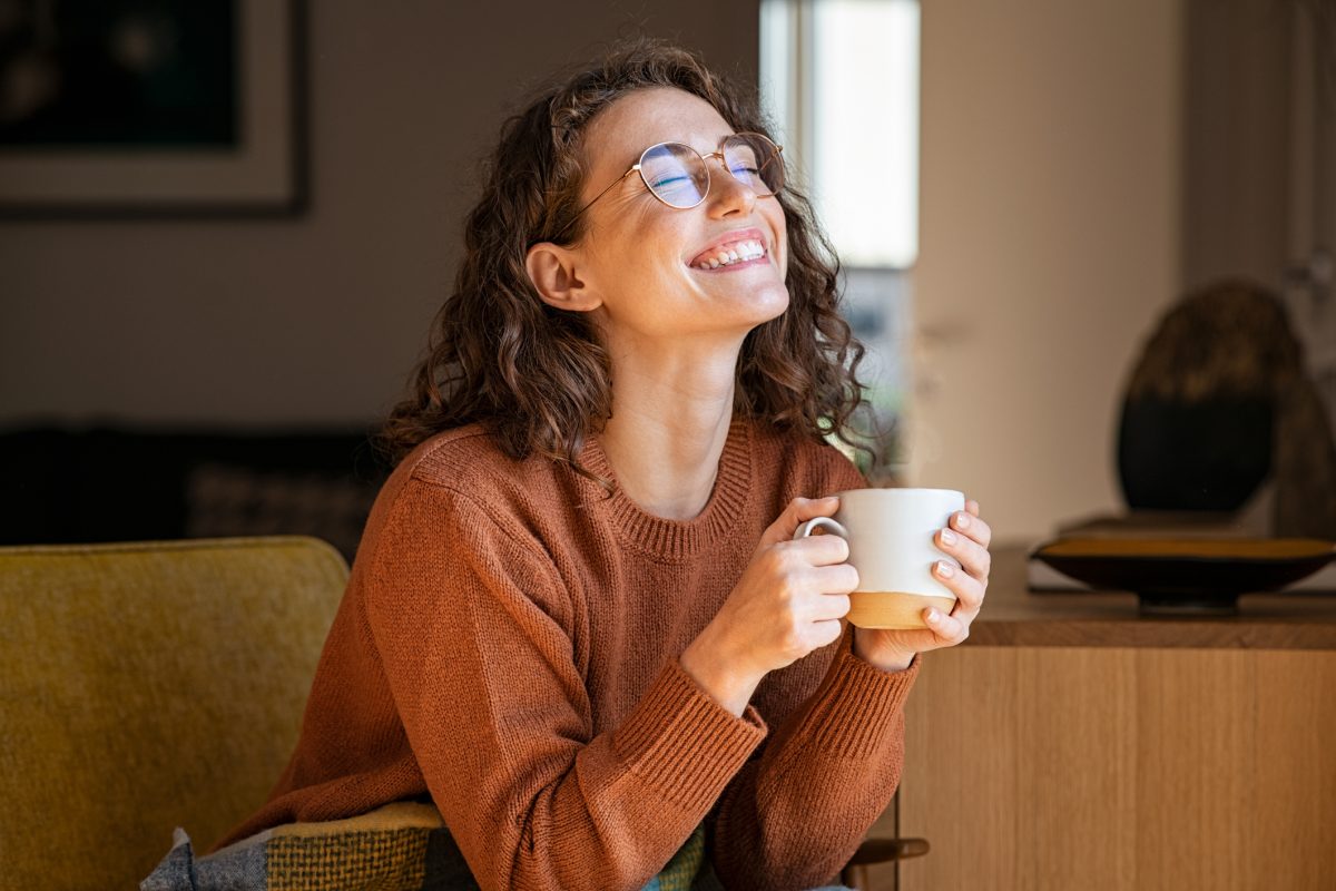 Dame med kaffekopp smiler