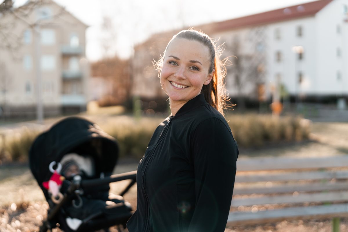 Ung mor utendørs med barnevogn